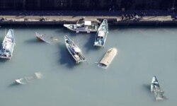 FILE - An aerial view shows capsized boats believed to be affected by the tsunami caused by an underwater volcano eruption on the island of Tonga at the South Pacific, in Muroto, Kochi prefecture, Japan, in this photo taken by Kyodo Jan. 16, 2022.