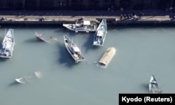 FILE - An aerial view shows capsized boats believed to be affected by the tsunami caused by an underwater volcano eruption on the island of Tonga at the South Pacific, in Muroto, Kochi prefecture, Japan, in this photo taken by Kyodo Jan. 16, 2022.