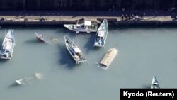 Picha iliyochukuliwa kutoka angani inaonyesha boti zilizozama ikiaminika ziliathiriwa na mlipuko wa volcano uliotokana na tsunami, Japan. Kyodo/via REUTERS ATTENTION EDITORS - 