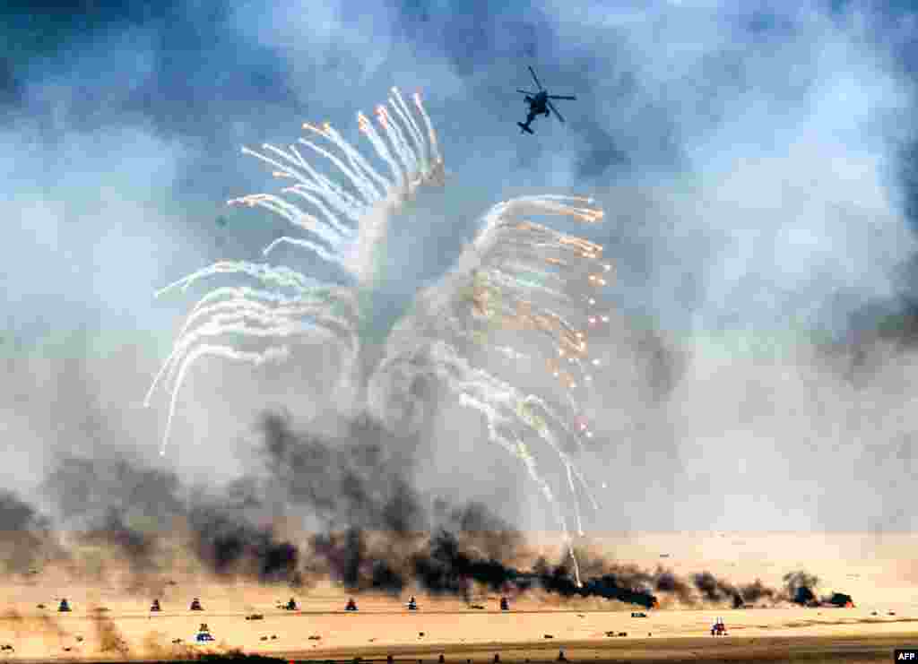 A Kuwaiti military helicopter takes part in a live-ammunition military exercise at Udaira military range, 140 kiolmeters north of Kuwait City.