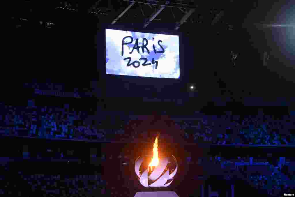 The Olympic torch and cauldron are seen with Paris 2024 displayed on the big screen during the closing ceremony REUTERS/Toby Melville