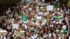 Health workers carry national flags and banners as they march during a protest calling on President Abdelaziz Bouteflika to quit, in Algiers, Algeria March 19, 2019. 