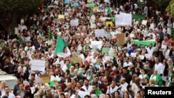 Health workers carry national flags and banners as they march during a protest calling on President Abdelaziz Bouteflika to quit, in Algiers, Algeria March 19, 2019. 