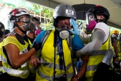 Veby Mega Indah, jurnalis asal Indonesia, dibantu oleh beberapa orang saat cedera, di Hong Kong, 29 September 2019. (Foto: AP)