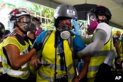 Veby Mega Indah, jurnalis asal Indonesia, dibantu oleh beberapa orang saat cedera, di Hong Kong, 29 September 2019. (Foto: AP)