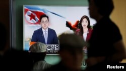 Para penumpang kereta di Seoul menonton siaran televisi yang memberitakan penembakan tiga rudal balistik oleh Korea Utara (5/9). (Reuters/Kim Hong-Ji)