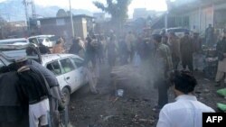 Pakistani security officals and local residents are seen gathered at the site of a bomb explosion at a market in Parachinar city, the capital of Kurram tribal district on the Afghan border on Jan. 21, 2017.