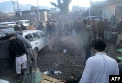 Pakistani security officals and local residents are seen gathered at the site of a bomb explosion at a market in Parachinar city, the capital of Kurram tribal district on the Afghan border on Jan. 21, 2017.