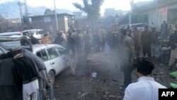 Les officiers de sécurité pakistanais et les résidents se sont rassemblés après l’explosion d’une bombe dans un marché de la ville de Parachinar, la capitale du district tribal de Kurram, dans la frontière afghane, le 21 janvier 2017.