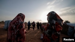 FILE - Survivors of sexual violence, who fled the conflict in El Geneina, West Darfur, walk together outside makeshift shelters for refugees in Adre, Chad, August 1, 2023. 