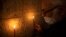Father Samuel Aghoyan, the Armenian superior at the Church of the Holy Sepulchre, holds candles to illuminate crosses etched into the ancient stone wall of the Saint Helena chapel inside the church. (REUTERS/Ronen Zvulun)