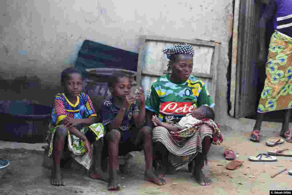 Ten-year-old twins, Yauseh and Asana, sit next to their mother, Zainabu. The girls are among the first set of twins in Kutara village in Nigeria allowed to live, instead of being killed.
