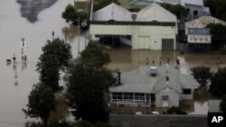 People wade through flood waters in the town of Moree, Northern New South Wales, Australia. (File Photo - February 3, 2012) 