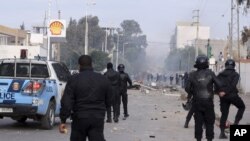 Police forces face protesters in the city of Ennour, near Kasserine, Tunisia, Wednesday, Jan. 20, 2016. Tunisia imposed a nationwide overnight curfew Friday in response to growing unrest as protests over unemployment across the country descended into violence in some cities.