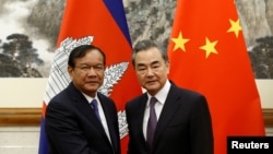 FILE - Cambodian Foreign Minister Prak Sokhonn and Chinese Foreign Minister Wang Yi pose for photos at Diaoyutai state guesthouse in Beijing, China May 31, 2019. (REUTERS/Florence Lo/Pool)