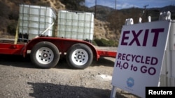 FILE - Gary Sutliff, 73, drives away after filling up water tanks with recycled water to revive dying plants in his garden, in Burbank, Los Angeles, California, United States, Sept. 12, 2015. The city has set up a five-spigot filling station to give free 