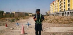 A Chinese police officer takes his position by the road near what is officially called a vocational education centre in Yining in Xinjiang Uighur FILE - Autonomous Region, China, Sept. 4, 2018.