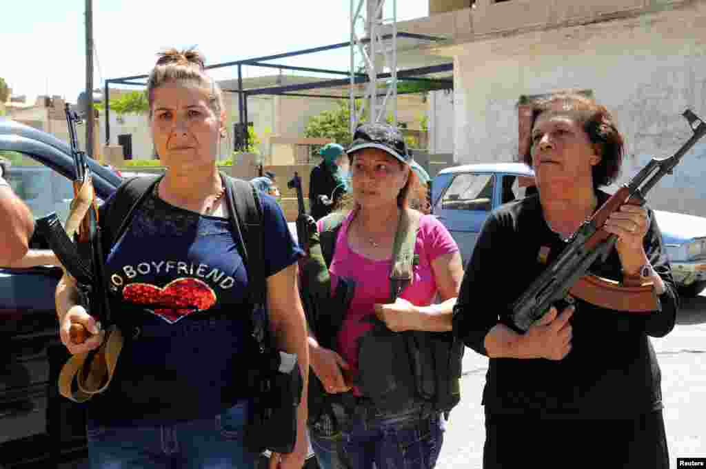 Women with guns are seen in the Christian village of Qaa, where suicide bomb attacks took place Monday, in the Bekaa Valley, Lebanon, June 28, 2016.