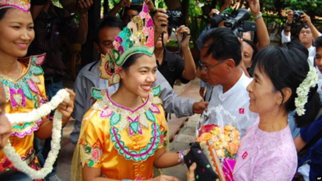 Burmese democracy icon Aung San Suu Kyi (R) receives flowers as she arrives at Bagan Hotel in Bagan, Burma, July 4, 2011