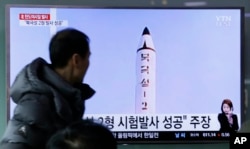 A man watches a TV news program showing a photo published in North Korea's Rodong Sinmun newspaper of North Korea's "Pukguksong-2" missile launch, at Seoul Railway station in Seoul, South Korea, Feb. 13, 2017.