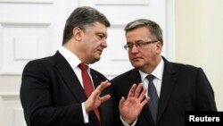 Ukrainian President Petro Poroshenko (L) speaks with Polish President Bronislaw Komorowski during their meeting in Warsaw, Dec. 17, 2014. 