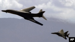 Le bombardier américain à long rayon d'action B1-B, accompagné d’un avion de chasse F-15, survole le Nevada, 19 juillet 2002.