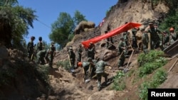 Tentara dan petugas lainnya tengah berupaya melakukan pencarian korban gempa di Dingxi, provinsi Gansu (22/7). Gempa berkekuatan 6.6 SR melanda wilayah ini, Senin pagi (22/7) dan korban tewas hingga saat ini dilaporkan telah mencapai 94 jiwa.