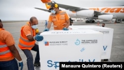 Workers take care of the shipment of Russia's Sputnik V vaccine at the airport, in Caracas, on March 29, 2021. 