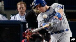 A. J. Ellis, de los Dodgers de Los Ángeles, pega un doble en el juego contra los Bravos de Atlanta, a los que derrotaron 6 carreras a una.