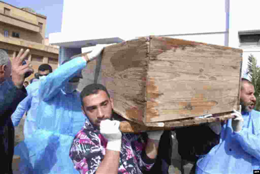 Men carry a coffin at Al-Jalaa hospital in Benghazi, Libya on Monday, Feb. 21, 2011. Libyan protesters celebrated in the streets of Benghazi on Monday, claiming control of the country's second largest city after bloody fighting, and anti-government unrest