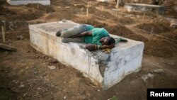 Un creuseur de tombes de victimes d'Ebola se repose dans un cimetière de Freetown, le 17 décembre 2014. (Reuters/Baz Ratner)