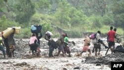 Haitianos cruzan el río La Digue en Petit Goave, al suroeste de Puerto Príncipe, donde un puente colapsó debido a las lluvias del huracán Matthew. Oct. 5, 2016.