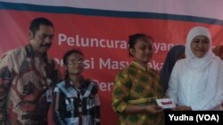 Menteri Sosial Khofifah Indar Parawansa (kanan) didampingi walikota Solo, F.X. Hadi Rudyatmo (kiri) membagikan kartu elektronik e-warong bagi warga miskin di Solo. (Foto: Dok)