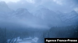 Kereta Api Canadian Pacific yang membawa sejumlah gerbong barang bergerak melalui jalur Morant's Curve dekat Danau Louise di Taman Nasional Banff, Alberta, Kanada, pada 29 November 2021. (Foto: AFP/Patrick T. Fallon)