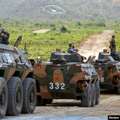 China's army soldiers sit on their tanks as they attend the opening of military exercise in Cambodia.