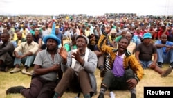 FILE - Miners gather at Wonderkop stadium outside the Lonmin mine in Rustenburg, northwest of Johannesburg, Jan. 30, 2014. 