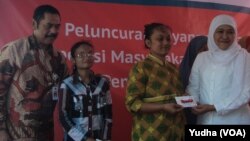 Menteri Sosial RI Dra. Khofifah Indar Parawansa (baju putih) didampingi walikota Solo, F.X. Hadi Rudyatmo (baju batik) membagikan kartu elektronik e-Warong bagi warga miskin di Solo (Foto: VOA/Yudha)