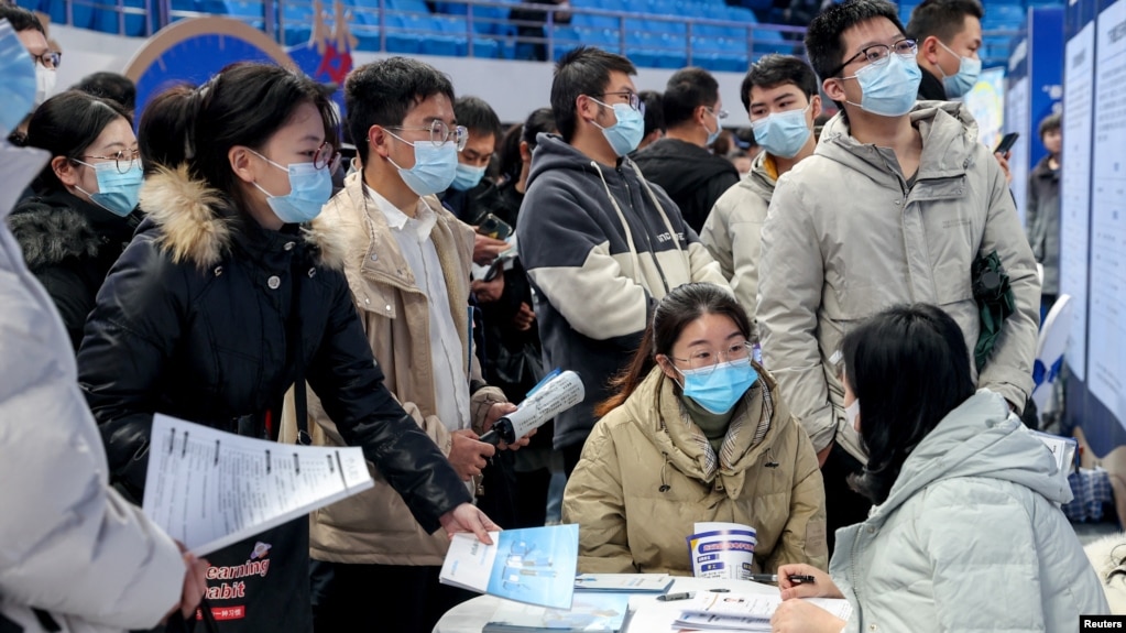 资料照片: 2023年2月9日武汉市招聘会上求职者在雇主展位