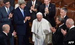 US Secretary of Stae John Kerry(2nd R),Treasury Secretary Jacob Lew (L)justices of the US Supreme Court and other cabinet members applaud as Pope Francis arrives to address the joint session of Congress on September 24, 2014 in Washington, DC.