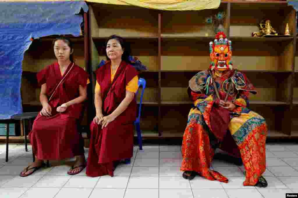 A Tibetan Buddhist monk wearing a traditional costume waits to perform a ritual dance on Vesak Day at the Enlightened Heart Tibetan Buddhist temple in Ipoh, Malaysia.