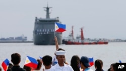 FILE - Relatives of crew of BRP Tarlac of the Philippine Navy wave Philippine flags to welcome its arrival at the South Harbor in Manila, Philippines, May 16, 2016. The radars Manila is purchasing from the U.S. will be mounted on Navy ships.
