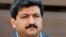 FILE - Pakistani journalist and television anchor, Hamid Mir talks with media representatives outside his home in Islamabad.