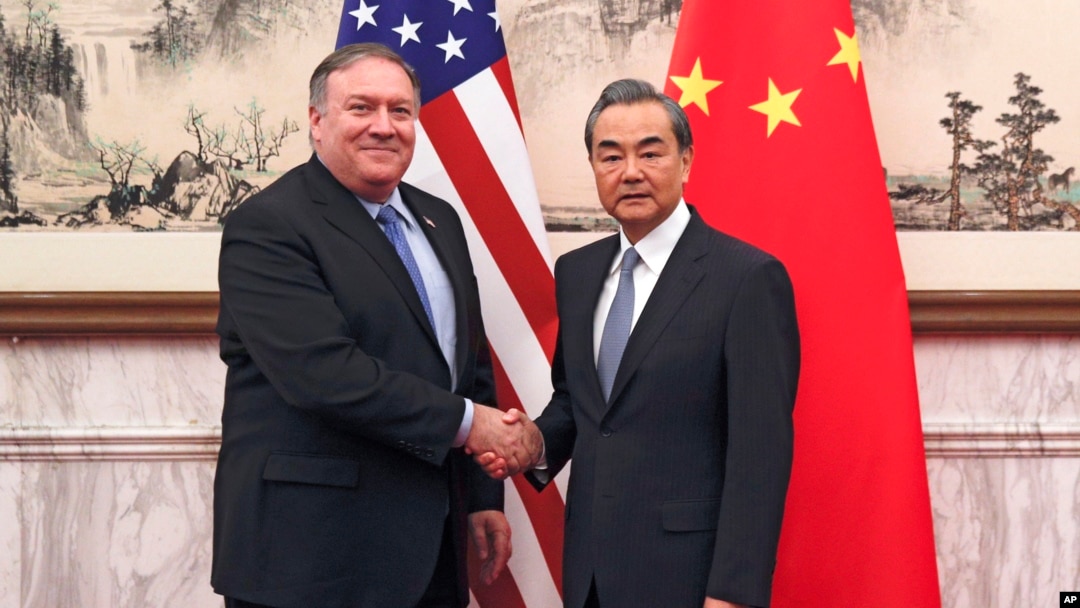 U.S. Secretary of State Mike Pompeo, left, shakes hands with Chinese Foreign Minister Wang Yi before their meeting at the Diaoyutai State Guesthouse in Beijing, Oct. 8, 2018.