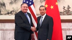 Menteri Luar Negeri Amerika Mike Pompeo (kiri) berjabat tangan dengan Menteri Luar Negeri China Wang Yi sebelum pertemuan di Wisma Negara Diaoyutai, di Beijing, 8 Oktober 2018.