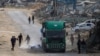 Warga Palestina berebut mengambil botol air yang jatuh dari truk bantuan kemanusiaan di Rafah, Jalur Gaza Selatan, 18 Februari 2025. (Foto: AFP)