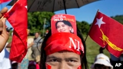 A supporter displays a picture of opposition leader Aung San Suu Kyi stuck in her headband during a campaign rally of the National League for Democracy in Thandwe, Myanmar, Oct. 17, 2015. 