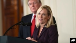 FILE - President Donald Trump, left, listens as Kirstjen Nielsen, right, a cybersecurity expert and deputy White House chief of staff, speaks in the East Room of the White House in Washington, Oct. 12, 2017