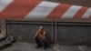 A worker rests next to a residential building damaged following a Russian drone attack, in Kyiv, on Sept. 26, 2024.