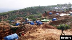FILE - Miners are seen at the mining settlement on the Kpangba hill in Mongbwalu in northeastern Democratic Republic of Congo, Nov. 16, 2016.
