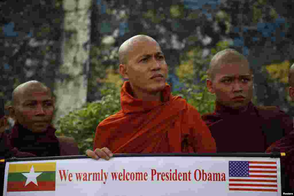 ບັນດາພະສົງທັງຫລາຍ ພາກັນຖືທຸງຊາດ ຂອງສະຫະລັດ ແລະມຽນມາ ຄູ່ກັນ ເພື່ອໄປຕ້ອນຮັບ ປະທານາທິບໍດີ ສະຫະລັດ ທ່ານ Barack Obama ເດີ່ນບິນສາກົນ ທີ່​ນະຄອນ​ຢ່າງ​ກຸ້ງ ໃນວັນທີ 19 ພະຈິກ 2012. (AP Photo/Carolyn Kaster)